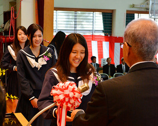 八重山農林高校の第77回卒業式で、渡久山修校長（右）から卒業証書を受け取る卒業生たち＝１日午前、同校