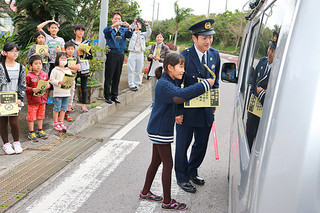 学校前を通過するドライバーにチラシを配り、不法投棄をしないように呼びかける富野小中学校の児童ら＝９日午後