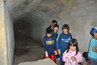 平喜納飛行場の関連壕内を見学する子どもたち＝22日午後、真栄里川良原地区