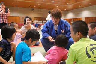 子どもたち銀メダルを見せる杉本美香さん＝10日午後、市総合体育館武道場