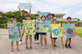 できあがった不法投棄防止看板を掲げる児童ら＝28日午後、富野小中学校