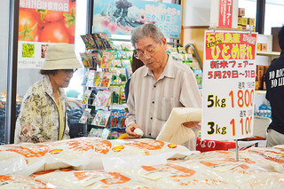 日本一早い「石垣島産ひとめぼれ」の新米を買い求める人たち＝29日午前、ゆらてぃく市場