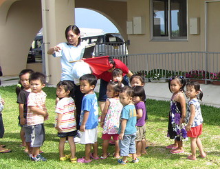 園庭に一時避難する祖納保育所の子どもたち＝５月29日、同保育所