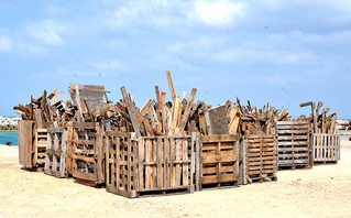 貨物輸送のために使われた後、港湾内に積まれた「パレット」。木くずの処理が課題となっている。＝資料写真・２０１５年２月、黒島港