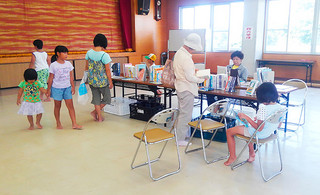 川平公民館で行われた移動図書館で、本に親しむ地域住民ら＝５日午後、同館（市立図書館提供）