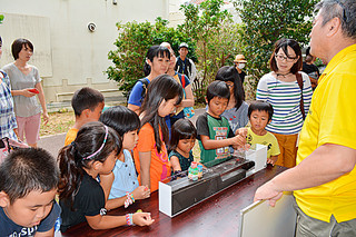 石垣市「親と子のお天気教室」で、津波実験に見入る子どもたち＝16日午後、市健康福祉センター