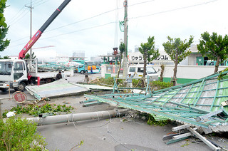 台風15号の暴風で鉄骨製のプレハブ屋根が飛ばされて電柱を倒壊した＝24日午前11時20分ごろ、りゅうせき八重山支店前