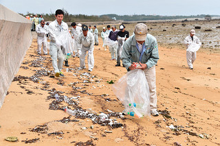 清掃活動には１００人余りが参加。漂着ごみを回収する参加者ら＝９月30日午後、同海岸