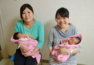 元旦に産まれた千晴ちゃんを抱く黒島秀美さん（左）と長女を抱く金城久美子さん＝４日午後夕、八重山病院