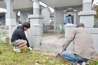 十六日祭を前に墓掃除を行う人たち＝21日午前、石垣市石垣