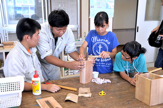 八重山特別支援学校の高等部の生徒たちが日ごろ学んでいる木工などの作業を小学生に教えた夏季体験教室＝21日午後、同校
