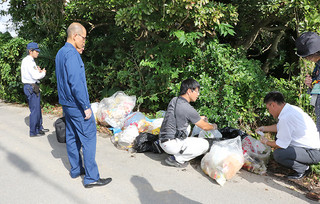 捨てられたごみ袋の中身を確認する市環境課の職員ら＝５日午後、平得のトゥメスク御嶽