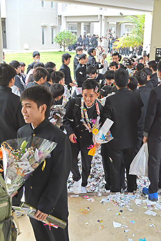 笑顔で花道を通る八重山高校の卒業生たち＝１日午後、同校