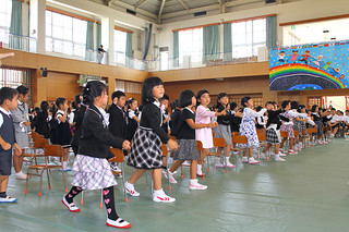 平真小学校に入学した新１年生。曲に合わせて踊りを披露する＝10日午前、体育館