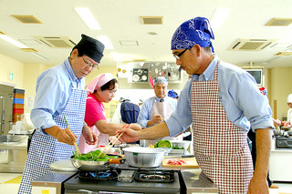 男のための料理教室」でヘルシーメニューを調理する参加者ら＝15日午前、石垣市健康福祉センター２階調理室