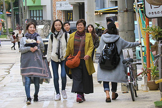 ひんやりとした空気の冷たさに、観光客も多めに服を着込んで外を歩いた＝10日午後、市街地