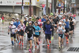 「ファンラン」で庭田清美さん（先頭）とともに楽しく走る参加者ら＝15日午前、７３０交差点付近