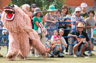 オープニングセレモニーの幕開けを飾る白保子ども獅子会の獅子舞。来場者も大喜びだった＝３日午前、新栄公園