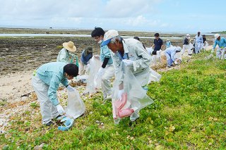 大浜海岸で行われた「河川・海岸愛護月間」のモデル清掃。参加者が漂着ごみなどを回収する＝７月31日午前、大浜海岸