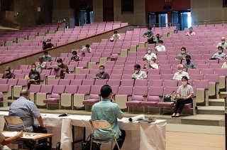 石垣市の新型コロナウイルス感染症対策について説明を受ける出席者ら＝20日午後、市民会館大ホール