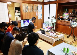 パソコンの画面を仏壇に向けオンラインの参加も交えて先祖を迎えた＝８月31日夜、市内新川の伊舎堂義男さん宅