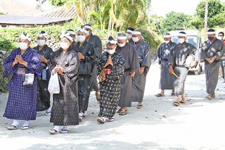 76年ぶりに昼間に世乞い歌を歌いながら根原家へ向かう公民館役員や村の顧問ら＝14日午前、竹富島