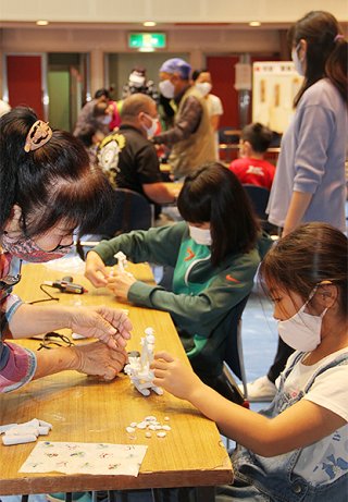 石垣市生涯学習フェスティバルと学び遊び体験広場が同時開催され、物作り体験に多くの親子連れが参加した＝14日午前、市民会館中ホール