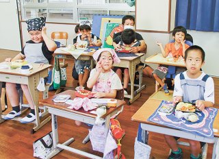 笑顔で弁当を見せる小学部3年の子どもたち＝27日午後、八重山特別支援学校