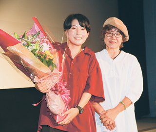 舞台挨拶終了後、花束を手に笑顔を見せる東盛あいか監督と母・朝子さん（左から）＝9日午後、桜坂劇場