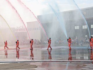 色とりどりの水を一斉放水する消防署員ら＝8日午後、石垣市消防本部
