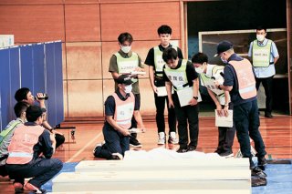 大規模災害に備え、遺体収容施設を運営するため訓練をする関係者ら＝27日午後、石垣市総合体育館
