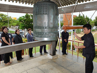 稚内市の平和祈念式に呼応し、世界平和の鐘を打ち鳴らす人たち＝20日正午すぎ
