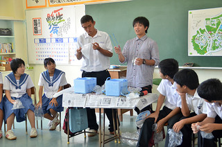 生徒たちに液体窒素の話をする琉大生の池田亘さん（中央右）＝24日午後、石垣第二中