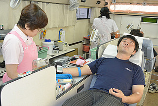 移動車両内で献血に協力する人たち＝４日午前、メイクマン石垣店敷地内