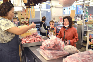 正月料理に使う豚肉を買い求める主婦ら＝30日午前、市公設市場