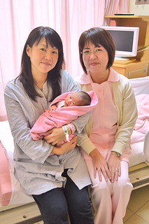 元日に産まれた次女を抱く飯田麻紀さん（左）と助産師の大底さん＝４日午後、八重山病院