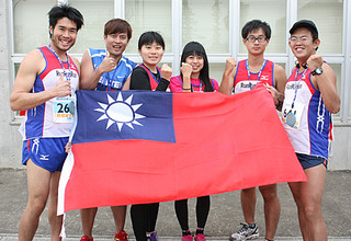 台湾の国旗を手に完走を喜ぶ台湾からの参加者＝26日午後、石垣市屋内練習場