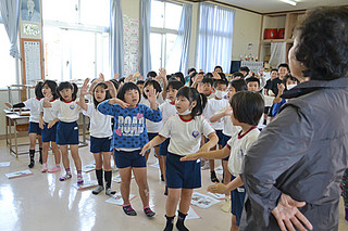 宮良小学校の方言教室で「月ぬ美しゃ」を踊る１、２年生たち＝26日午前、同校