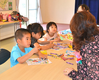 天川学童クラブ開所式後、塗り絵などを楽しむ子どもたち＝１日午後、天川公民館