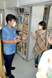 県立図書館八重山分館に収蔵されている資料を視察する市立図書館の吉見武浩館長（左）ら＝26日午後