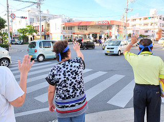 ドライバーに手を降って支持を呼びかける運動員ら＝３日夕、石垣市内
