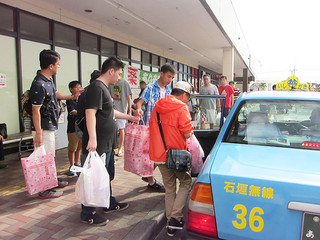 大型店でのショッピングを終え、タクシーに乗り込む台湾人観光客ら。乗務員も中国語を学んでサービス向上を目指す＝７月中旬、マックスバリュやいま店