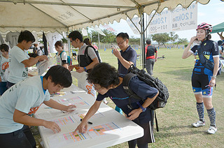 石垣島ライド２０１４の受け付けに訪れた参加者ら＝25日午後、舟蔵児童公園