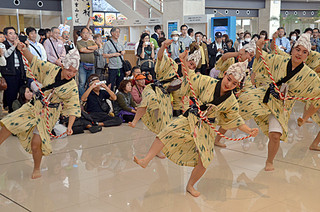 開港２周年で踊りを披露し、観光客を喜ばせた八重山高校郷土芸能部の部員ら＝７日午前、南ぬ島石垣空港