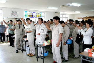 石垣島製糖の今期操業終了を祝い乾杯する関係者ら＝23日午後、同社第２会議室