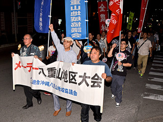 メーデーに合わせたデモ行進で賃上げなどを訴える参加者＝１日夜、市役所付近