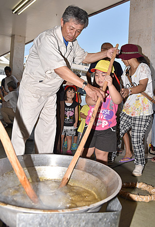 黒糖の日を前に行われたイベントで黒糖作りに挑戦した子どもら＝９日午前、ＪＡファーマーズマーケットゆらてぃく市場