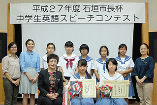 中学生英語スピーチコンテストで１位の中川美帆さん（前列中央）、３位の高橋萌空さん（同右）と出場者ら＝13日午後、市立図書館視聴覚室