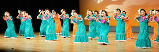 石垣市婦人連合会の第24回芸能大会で華麗なフラダンスを披露する新栄町婦人会の会員ら＝４日午後、市民会館大ホール