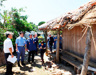 台風被害を受けた家屋を視察する政府調査団のメンバーら＝１日午後、祖納